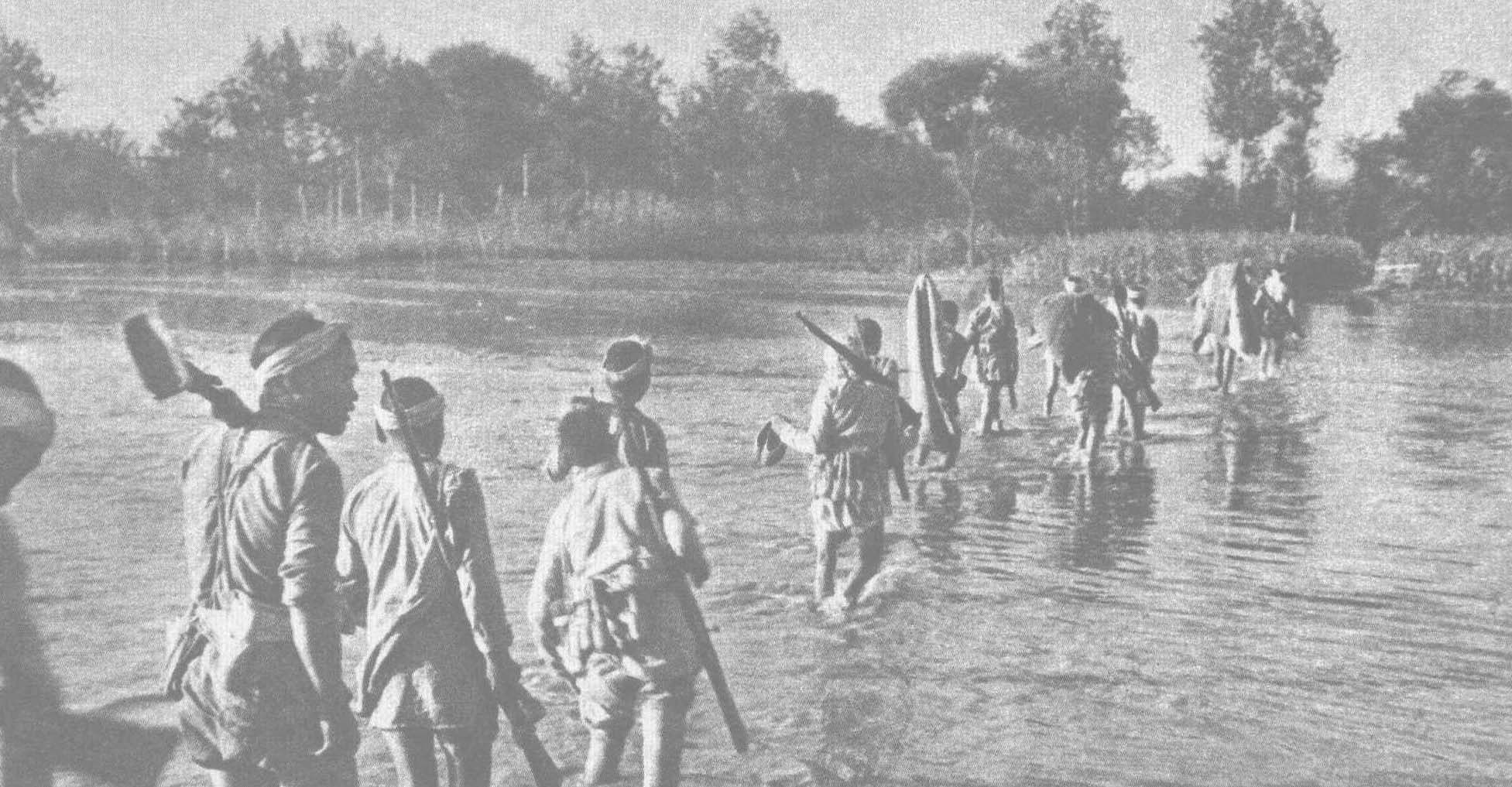 1944年7月，冀中八路军攻克河北定县以南小漳据点。图为渡过沙河向小漳开进的部队